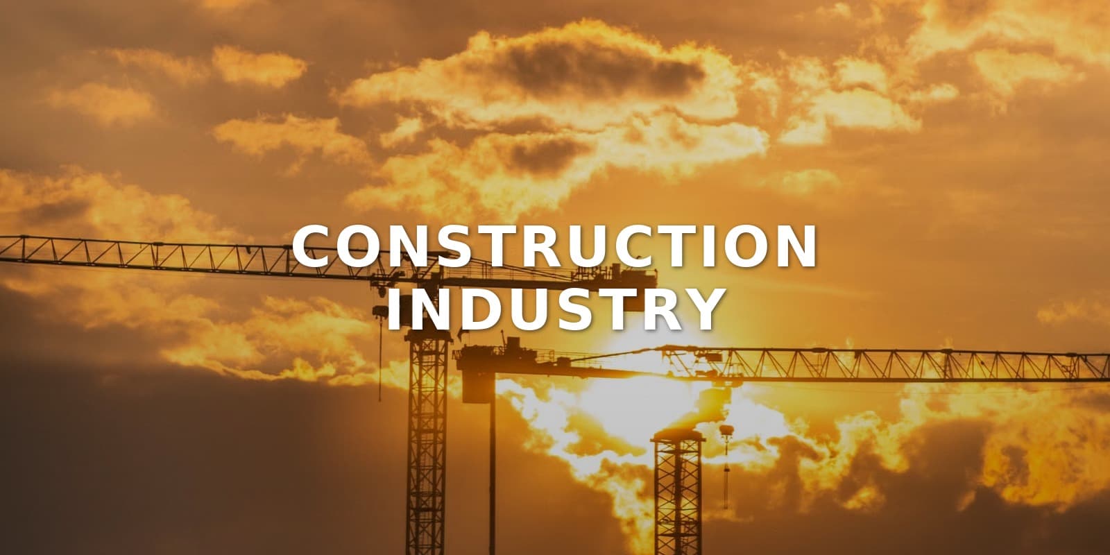 Construction Industry: tower cranes against a sunset sky